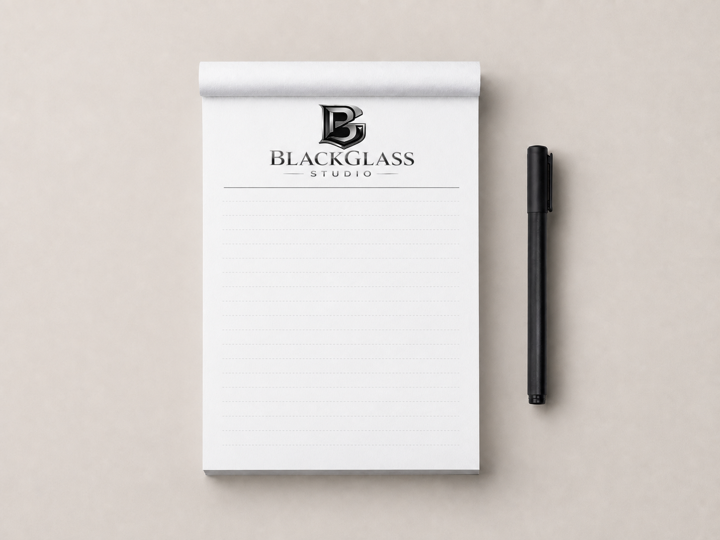 Lined notepad branded with the complete Black Glass Studio logo